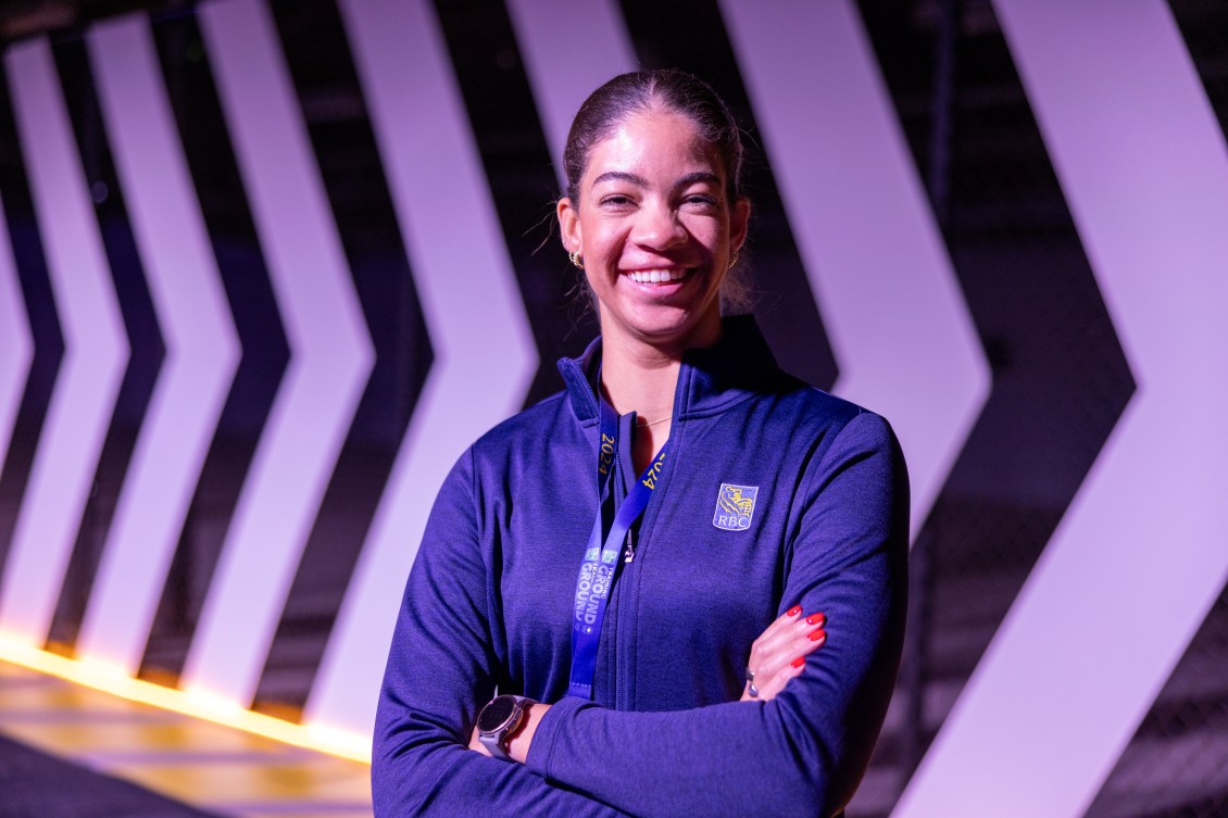 Sarah Douglas smiles with her arms crossed while wearing a blue RBC sweater