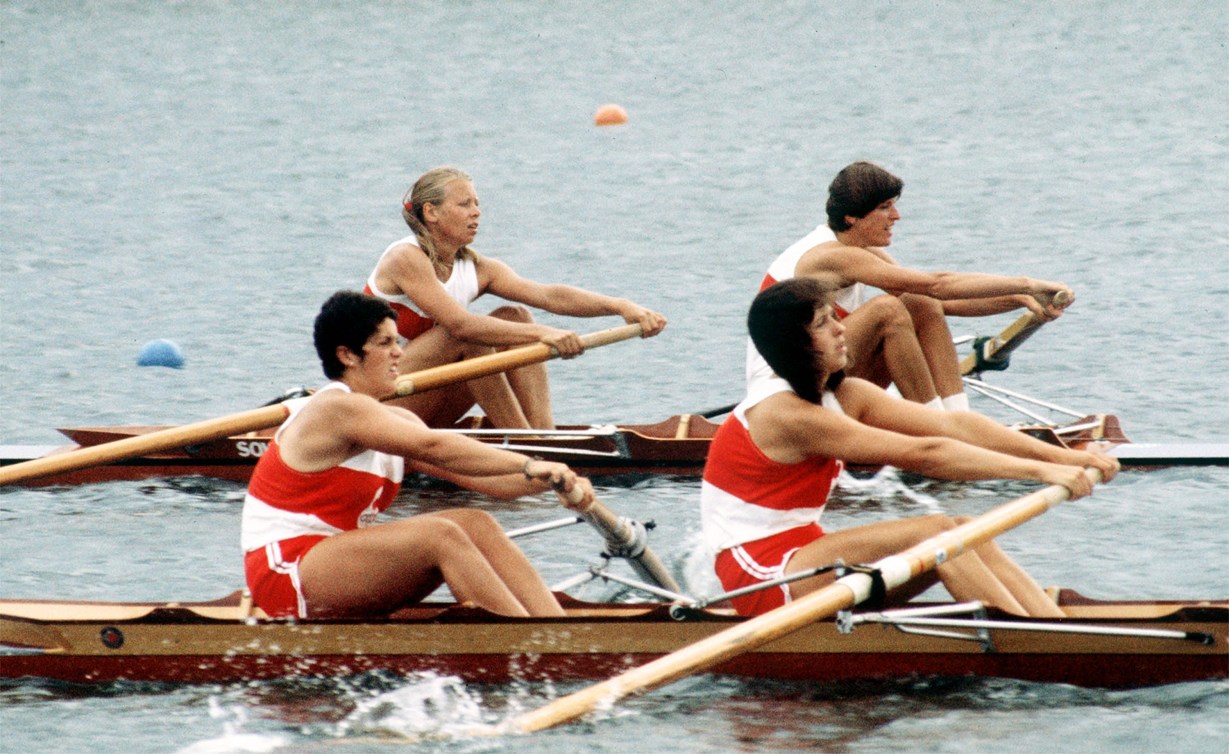Two Canadian rowers pull in tandem while wearing red and white uniforms