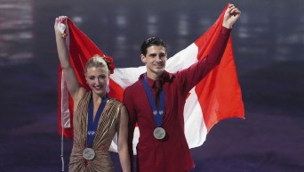 Silver medalists Piper Gilles and Paul Poirier, of Canada, pose for a photos during a medal ceremony for ice dancing at the figure skating world championships,