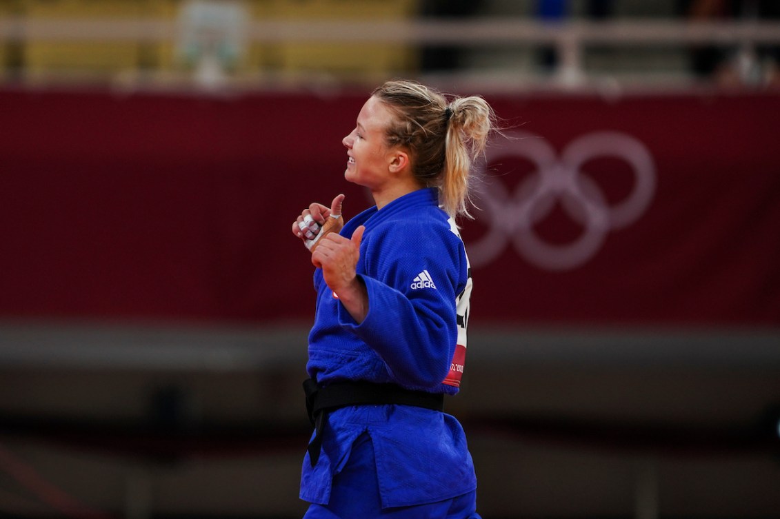 female athlete puts thumb us while walking off the mat