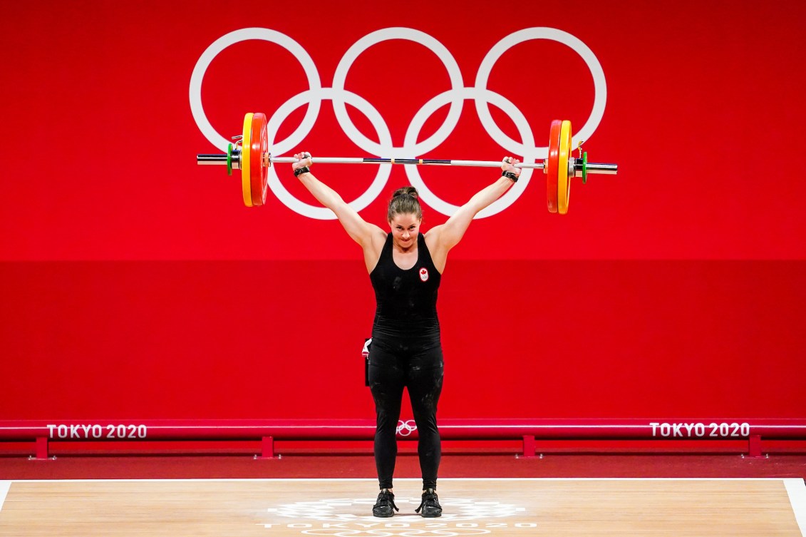 Maude Charron with the bar bell lifted above her head 